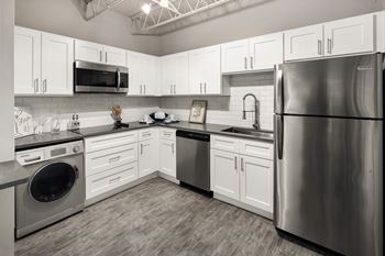 A kitchen with white cabinets and stainless steel appliances